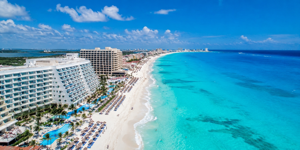 Cancun Hotel Zone strip showing older affordable hotels next to larger resorts along the beach