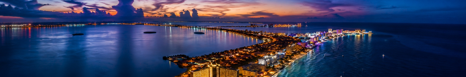 Cancun Hotel Zone nightlife strip lit up after dark, used to compare the city's four different night scenes